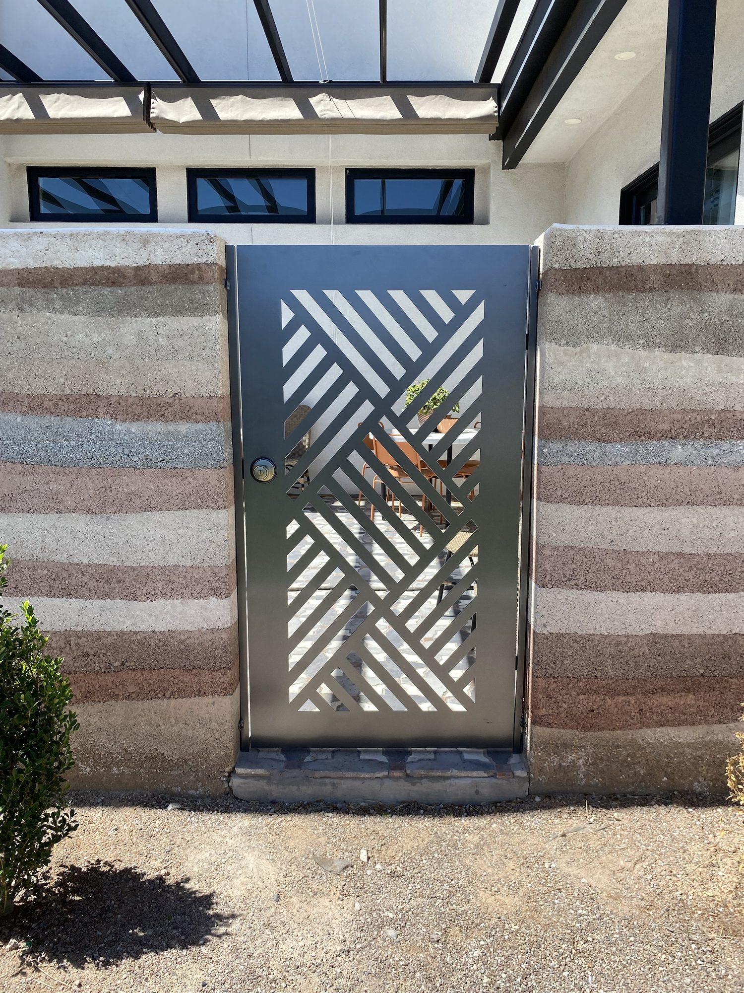 Custom entry gate with a diagonal chevron cut pattern in steel, fabricated by Sandbar Fabrication