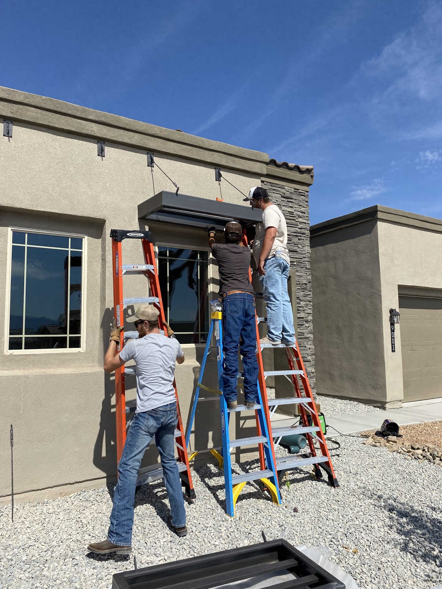 Installing a custom steel entry canopy above a garage opening